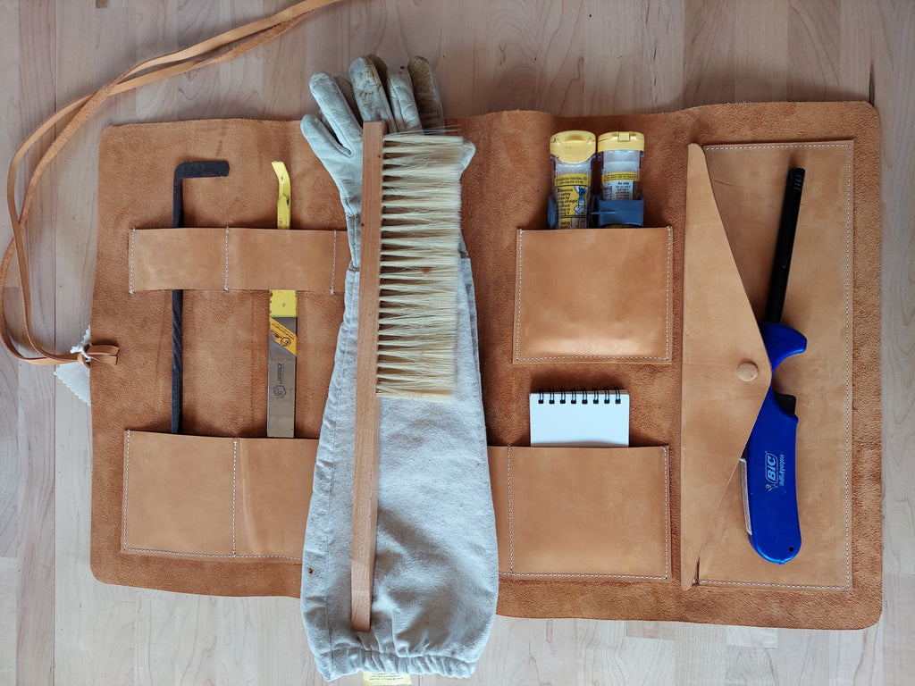 Leather tool roll made to store beekeeping tools.