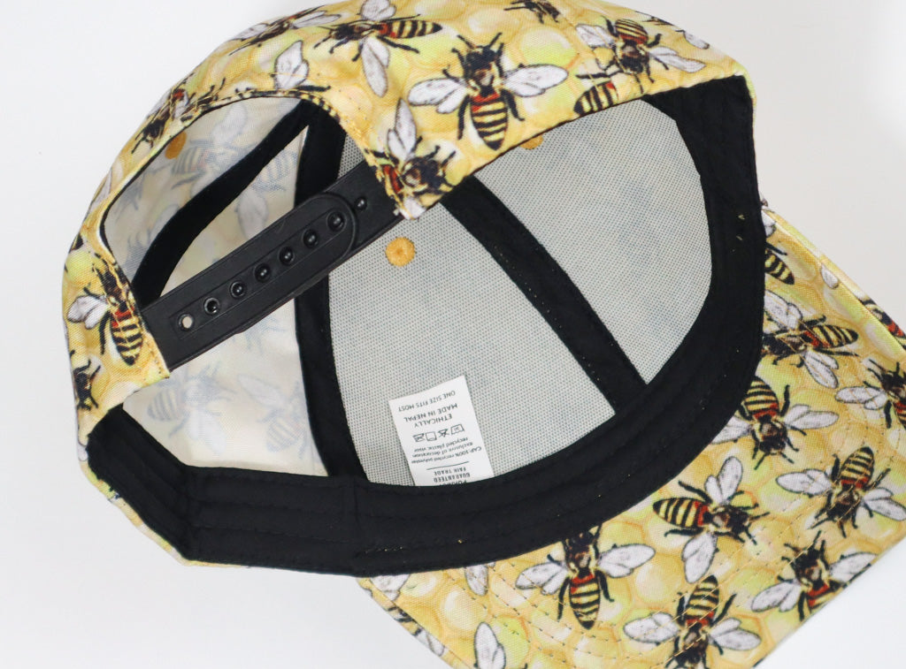 Baseball hat with yellow honeycomb background and large honeybees.